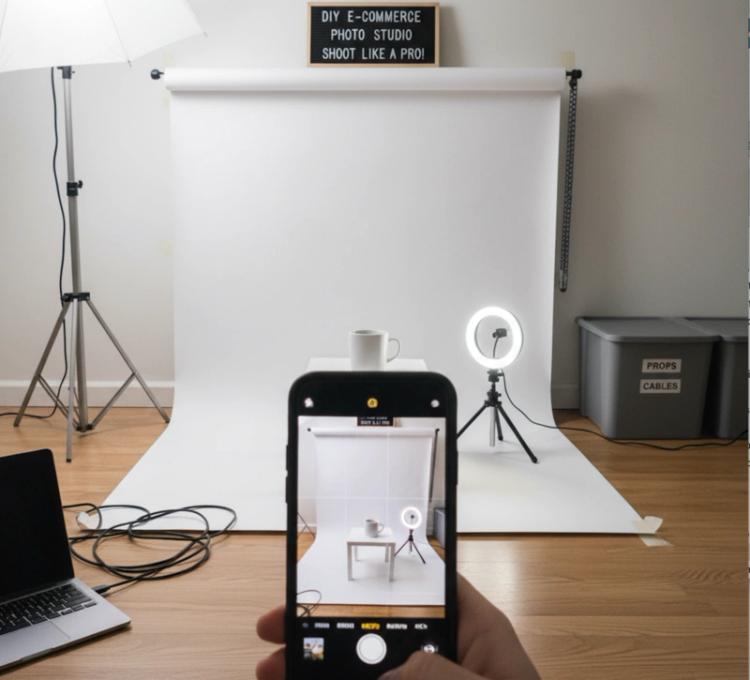 Smartphone taking product photo on white background with simple home photography setup