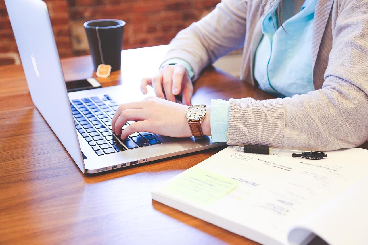 Professional creating LinkedIn content strategy on laptop with growth metrics