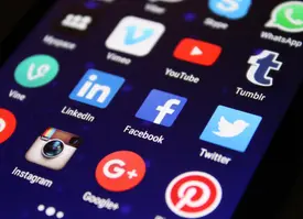 Creador de contenido trabajando con múltiples dispositivos mostrando diferentes plataformas de redes sociales y formatos de contenido para optimizar la estrategia de reutilización