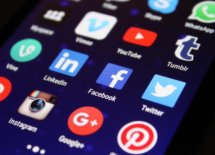 Creador de contenido trabajando con múltiples dispositivos mostrando diferentes plataformas de redes sociales y formatos de contenido para optimizar la estrategia de reutilización