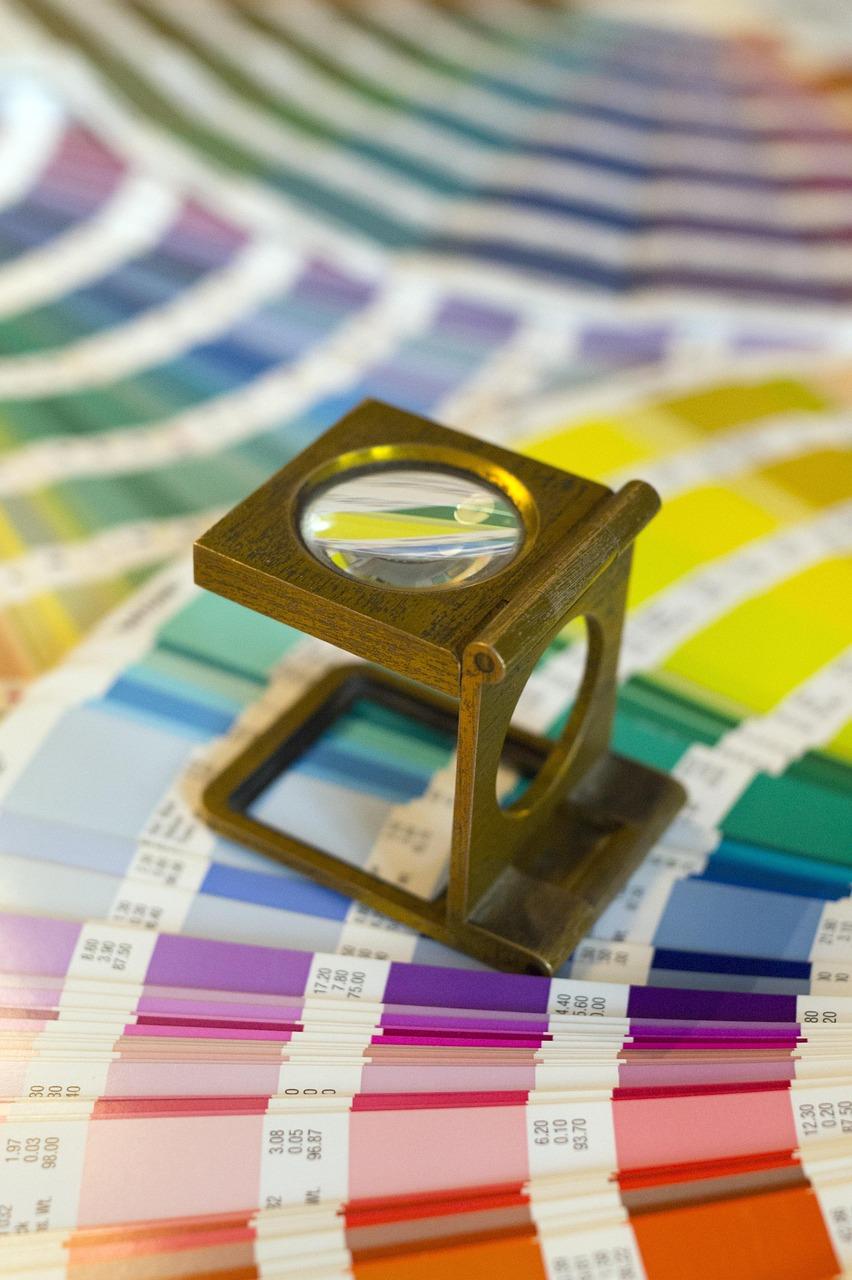 Nhà thiết kế so sánh các mẫu in CMYK với màn hình kỹ thuật số RGB hiển thị độ chính xác màu sắc trên các phương tiện khác nhau