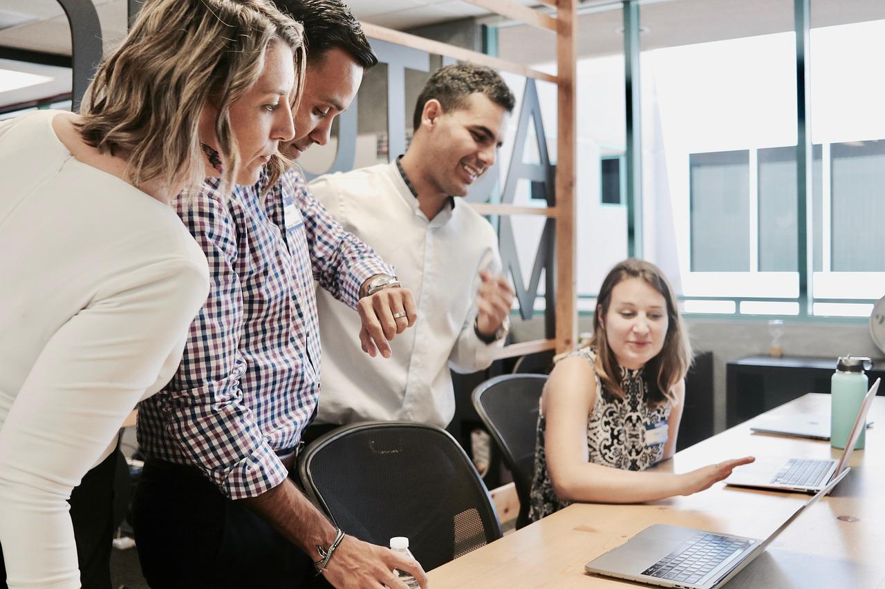 Équipe créative de marketing collaborant sur une stratégie de contenu avec plusieurs appareils et écrans