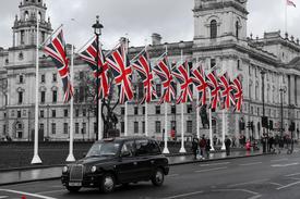 Globales Geschäftstreffen mit einem vielfältigen internationalen Team, das Strategien zur Inhaltslokalisierung rund um eine Weltkarte mit britischer Flagge und digitalen Kommunikationssymbolen diskutiert