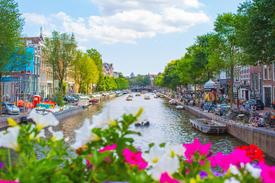 Distrito de negócios de Amsterdã com edifícios modernos e elementos culturais holandeses representando oportunidades de expansão no mercado da Holanda