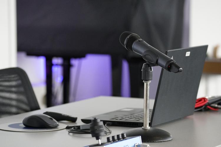 Professionelles Aufnahmestudio mit Mikrofon, Kopfhörern und Computerbildschirm mit spanischer Sprachinhalts-Erstellungssoftware und Wellenformmustern