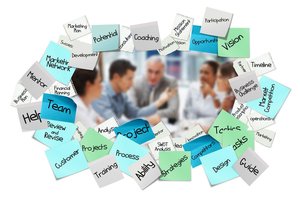 Marketing team collaborating on digital assets with laptops, tablets, and creative materials organized on modern workspace