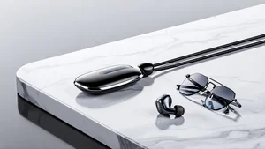 Futuristic wearable devices including smart glasses pendant and earbuds on marble surface