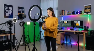 Content creator with smartphone in modern studio setup with professional equipment