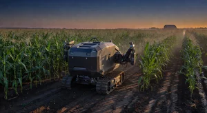 Autonomous farming robot working between crop rows in a futuristic but real agricultural setting with dawn lighting