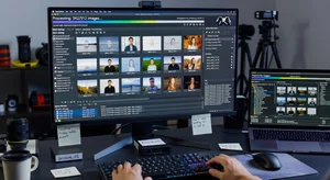 Computer workspace showing bulk photo editing software processing hundreds of images